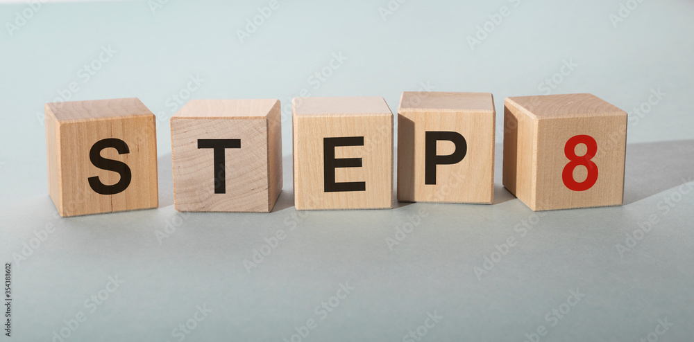 Poster step by step concept. step 8 eight text on wooden cube blocks on blue grey table