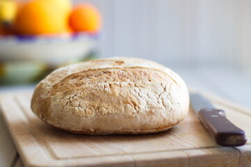 freshly baked rustic loaves of bread on wooden board and with a knife