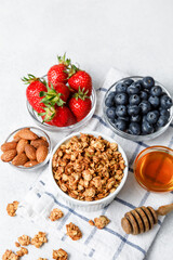 Homemade oatmeal granola bowl with berries on white background.