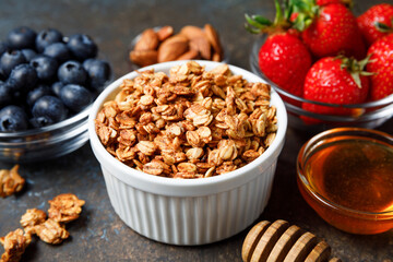 Homemade oatmeal granola bowl with berries on dark background.