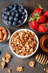 Homemade oatmeal granola bowl with berries on dark background.