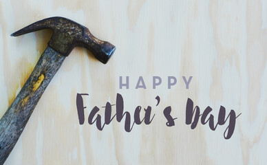 Happy Father's Day graphic with hammer tool isolated on wood background, rustic holiday celebration...