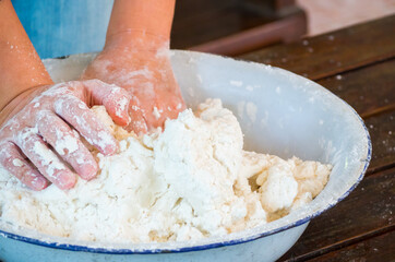 Woman hands kneading white flour for baking or food on table