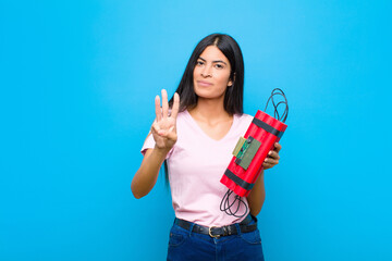 young pretty latin woman smiling and looking friendly, showing number three or third with hand...