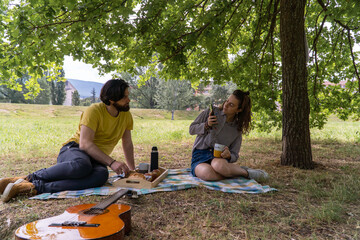 A couple having a picnic in the middle of nature. Having breakfast and enjoying the day.
