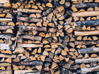Woodpile with a lot of birch and spruce logs. Chopped a lot of firewood neatly stacked in a pile,...