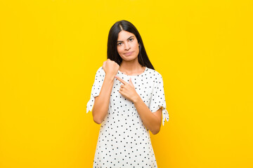 young pretty latin woman looking impatient and angry, pointing at watch, asking for punctuality,...