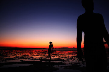 young couple holding hands on sunset sky background