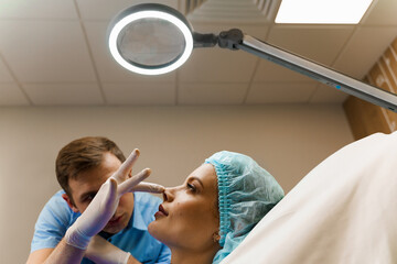 Facebuilding. Septoplasty and nose rhinoplasty. Doctor touches girl nose on consultation....