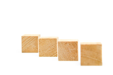 Wooden cubes on a white background. Four identical cubes lie, stand in a row along the diagonal