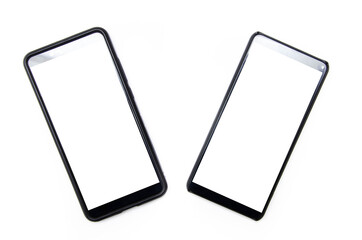 Two smartphones of black color with a white screen lie on a white background nearby, deviated from...