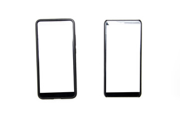 Naklejka premium Two smartphones of black color with a white screen lie on a white background nearby, deviated from each other, top view and bottom from an angle in macro
