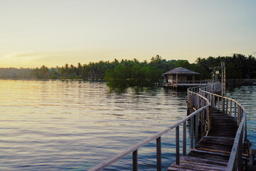 Naklejka premium Beautiful landscape. Sunset on the seashore. Wooden bridge on the beach, Siargao Island, Philippines.