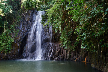 Fototapeta na wymiar Tropical waterfall. Wet rock and pool.