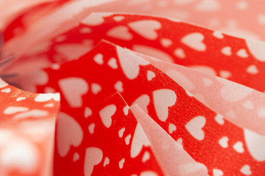 Red bright ribbon with heart shapes white pattern macro