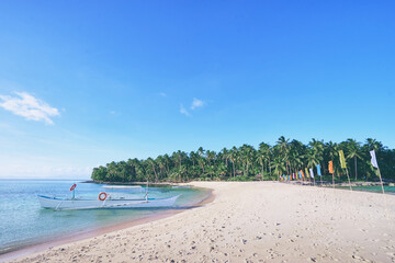 Beautiful landscape. White sand beach with colorful flags on it. Siargao Island, Philippines.