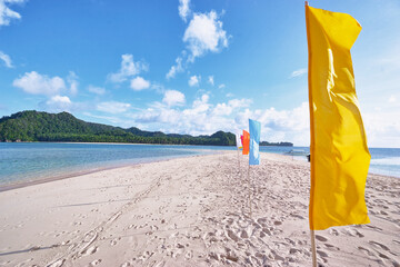 Fototapeta na wymiar Beautiful landscape. White sand beach with colorful flags on it. Siargao Island, Philippines.