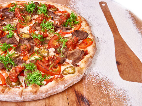 Meat Pizza with jalapeno on wood decorated with spreaded wheat