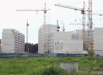 Construction crane and building under construction in the city. Apartments for sale. Housing concept
