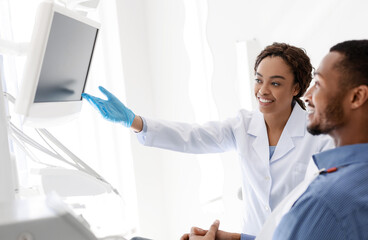 Dentist and patient looking at blank display at clinic