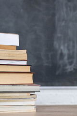 School readings arranged in a row at the front and in the background there is a school board not properly washed.