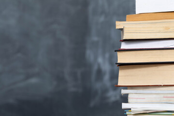 School readings arranged in a row at the front and in the background there is a school board not properly washed.