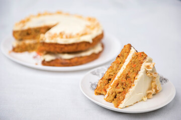 Piece of carrot cake with carrot cake on the background