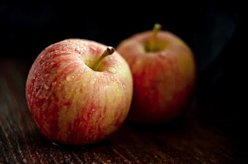 Rustic apples with drops of water on a dark background