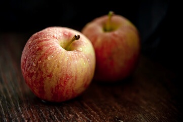 Rustic apples with drops of water on a dark background