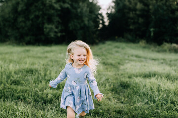 little blonde girl running in a field