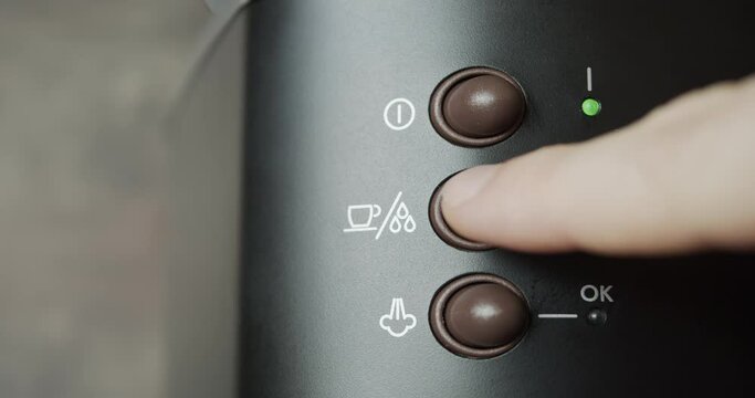 Using espresso coffee machine close-up - pushing on and off buttons and making a shot of fresh coffee