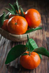 Fresh tangerines with leaves on a wooden old background