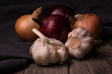 Onions and garlic on old wooden background close-up