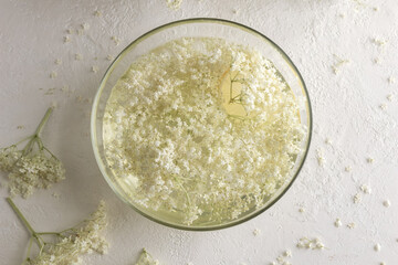 Macerating elder flowers in water to prepare herbal syrup