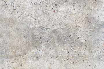 Old stained concrete wall with multi-colored pebble stones. Texture of gray color cement background, dry scratched surface wall cover sand, shabby detail.