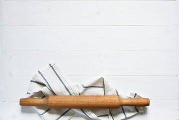 Wooden rolling pin with a napkin on a concrete background with a place for a recipe. View from above. Flatly