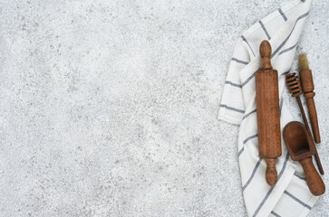 Wooden rolling pin with a napkin on a concrete background with a place for a recipe. View from above. Flatly