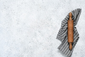 Wooden rolling pin with a napkin on a concrete background with a place for a recipe. View from above. Flatly