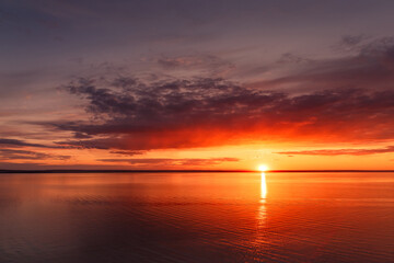 Fototapeta premium Beautiful view of the sea and sunset. Beautiful nature landscape with dramatic clouds sunset sky and views of the sea surface. Postcard view. Nature. Concept. Golden sunset