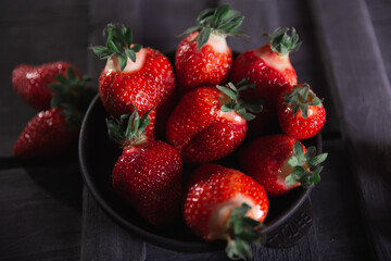 Fresh ripe strawberries on a black wooden background