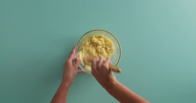 potato cooking in a pot of boiling water, taking put and cutting in half, scooping out the middle and putting cheese, eggs and bacon bits inside to make a loaded potato