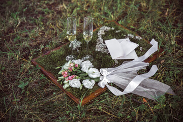 Wedding floristry bouquet and invitation on green moss close-up