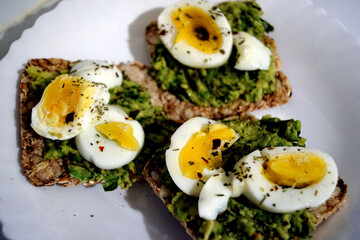 Saint Petersburg, Russia - May 19, 2020: crispbread with avocado, eggs and spices on a plate