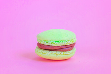 Sweet almond colorful unicorn yellow macaron or macaroon dessert cake isolated on trendy pink pastel background. French sweet cookie. Minimal food bakery concept Copy space