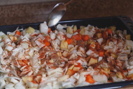 Vegetable oil is poured from tablespoon of vegetables