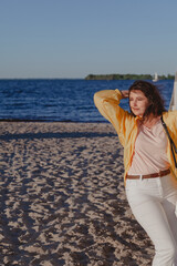 Nice girl leans on wooden structure on beach