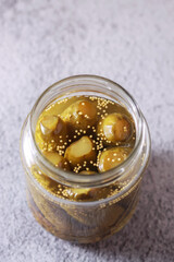 fermented cucumbers, pickled pickled cucumbers in a glass jar. a healthy vegan snack full of probiotics for intestinal health and digestion, homemade canned cucumbers. Place for text.