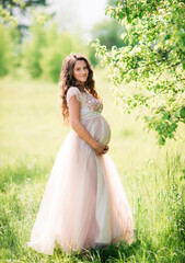 Fototapeta na wymiar Pregnant happy woman in white dress outdoors in the countryside on a warm sunny day