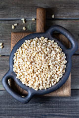 Cedar nuts in wooden pot on rustic background 