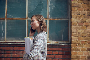 Young business woman talking on her phone in front of old new yourker building